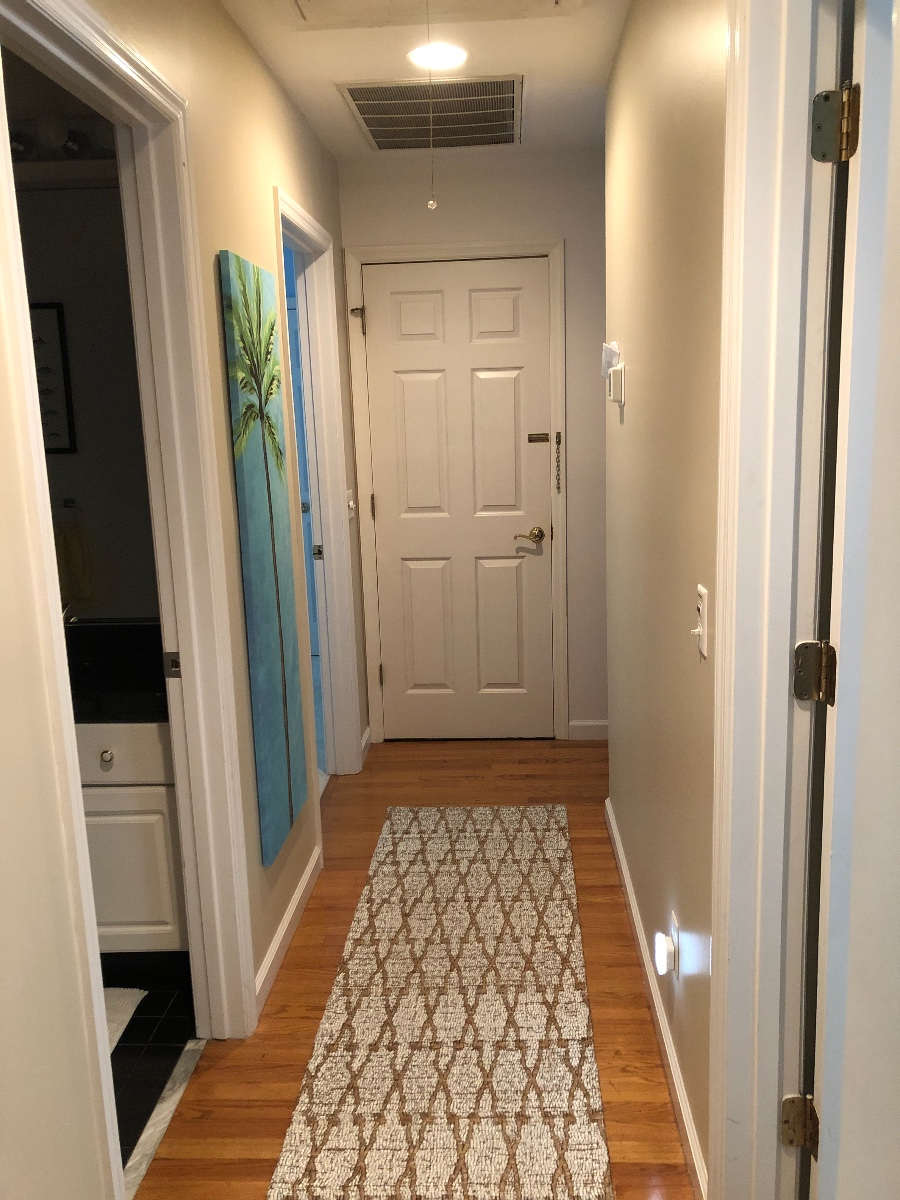 Hallway with bedrooms and bath and door to garage/playroom area