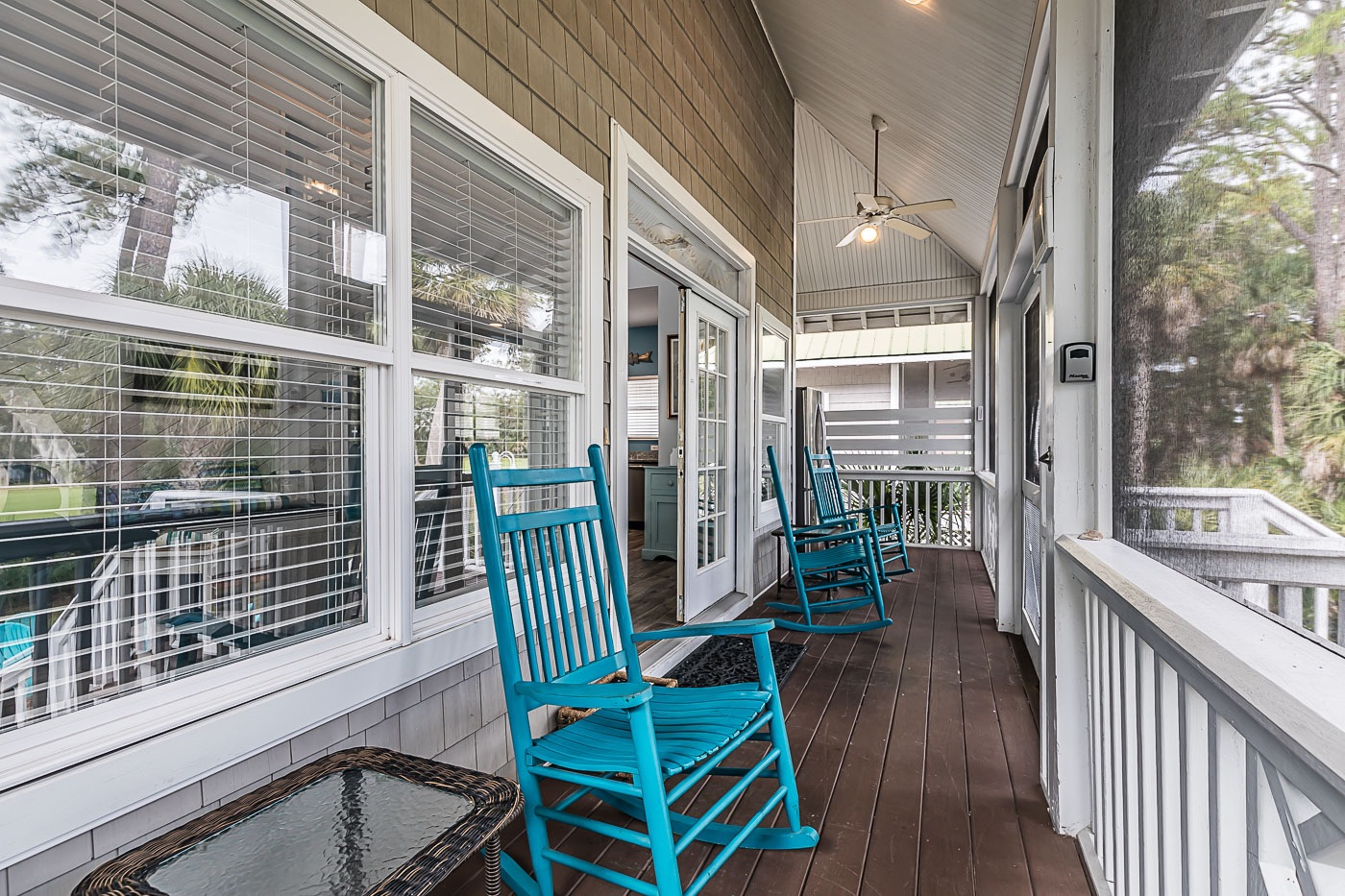 Screened in back porch with 4 adult rocking chairs and one child rocking chair.